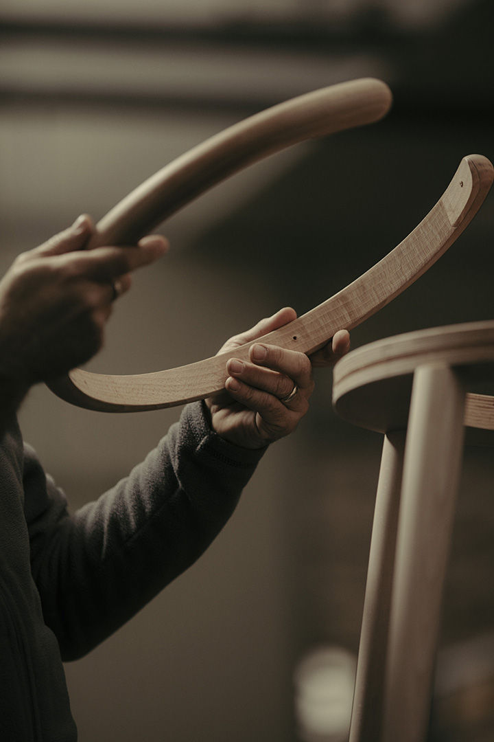 Craftsman shaping a curved bentwood chair component